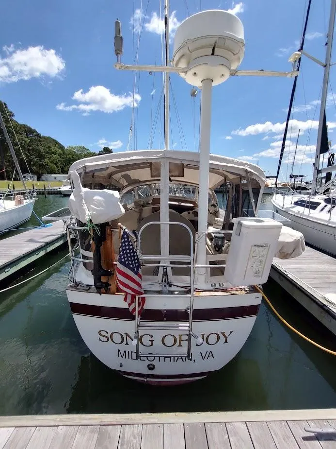 Slide: The Image of 1982 Ta Shing Tatoosh 42 sailboat docked, named "Song of Joy," with American flag. - 2