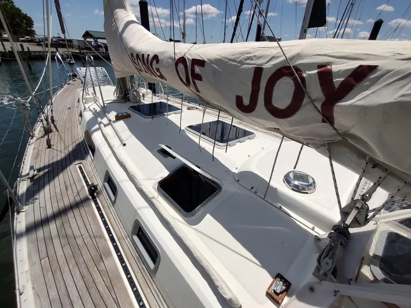 Slide: The Image of 1982 Ta Shing Tatoosh 42 sailboat deck with "Song of Joy" sail, docked in marina. - 6