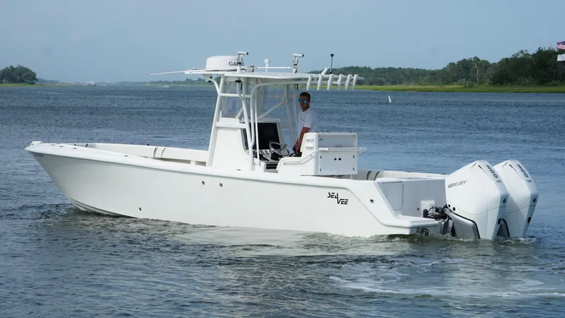Slide: The Image of 2004 SeaVee 310B boat on water, featuring twin outboard engines and a center console. - 10