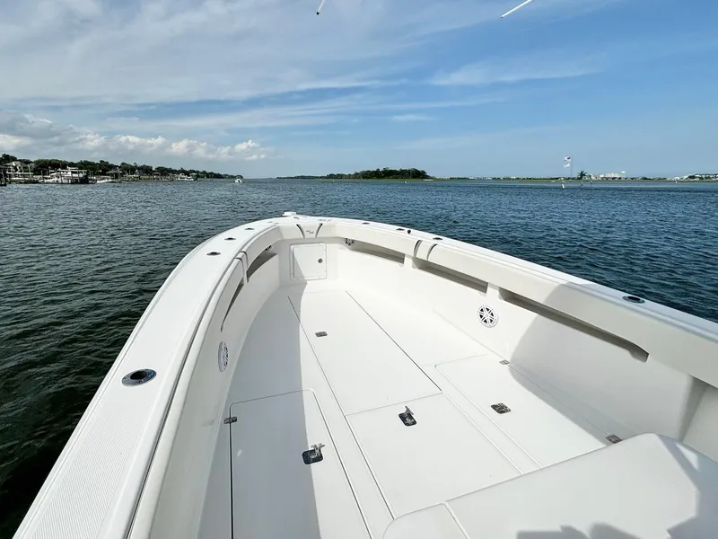 Slide: The Image of 2004 SeaVee 310B boat on calm water, clear sky, spacious deck. - 13