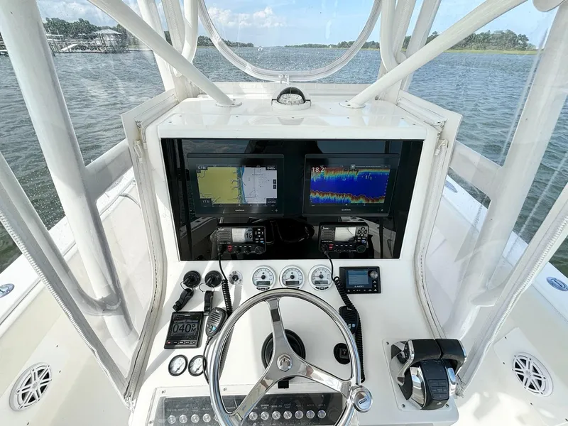 Slide: The Image of 2004 SeaVee 310B boat cockpit with navigation screens and steering wheel on open water. - 14