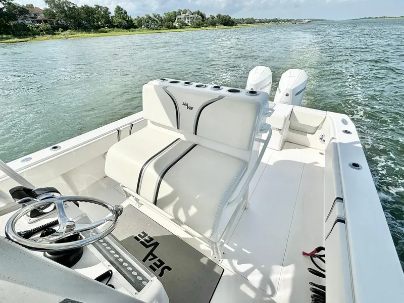 Slide: The Image of 2004 SeaVee 310B boat with dual engines cruising on a scenic waterway. - 16