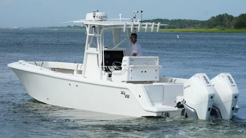 Slide: The Image of 2004 SeaVee 310B boat with twin engines cruising on a calm waterway. - 2