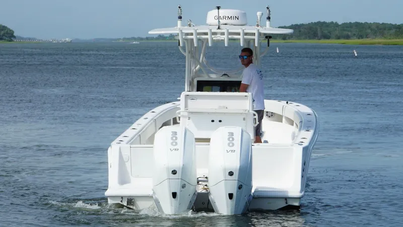 Slide: The Image of 2004 SeaVee 310B boat with dual engines cruising on a calm waterway. - 3