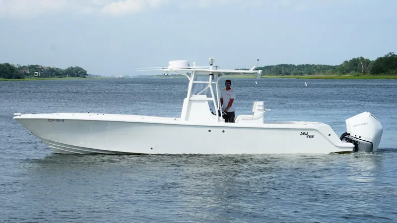 Slide: The Image of 2004 SeaVee 310B boat on calm water, featuring a sleek white design and center console. - 4