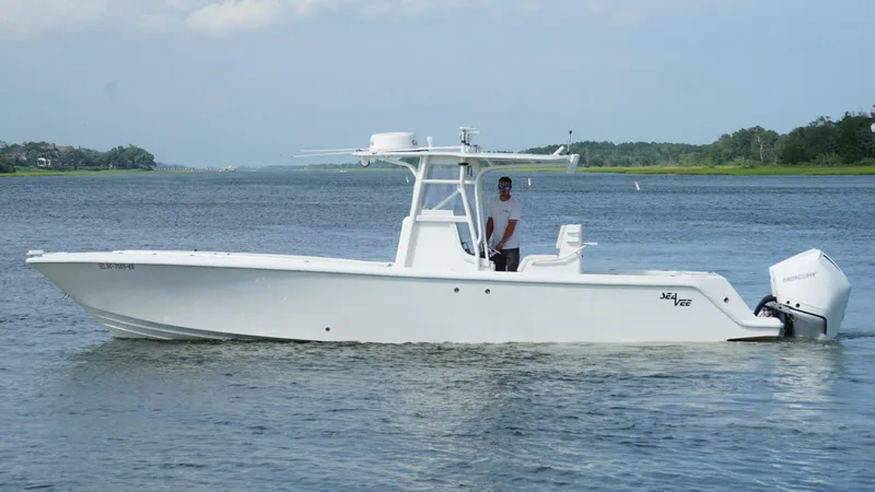 Slide: The Image of 2004 SeaVee 310B boat on calm water, featuring a sleek white design. - 5