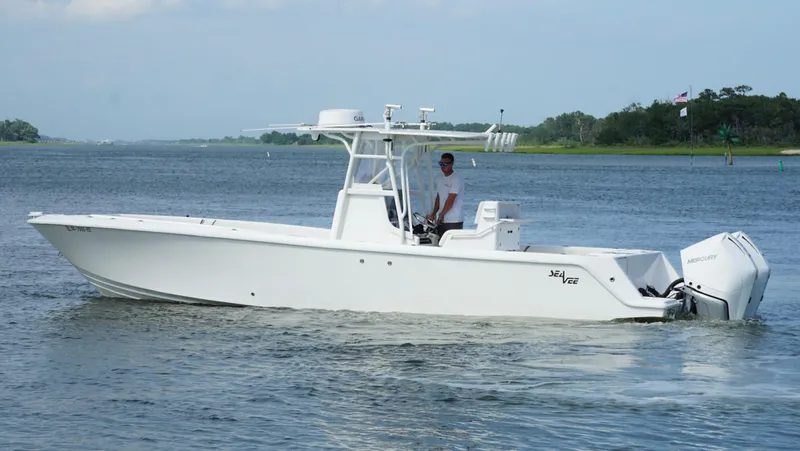 Slide: The Image of 2004 SeaVee 310B boat cruising on a calm waterway. - 6
