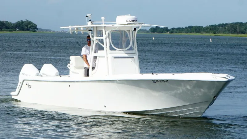 Slide: The Image of 2004 SeaVee 310B boat cruising on a calm lake with a clear sky. - 8