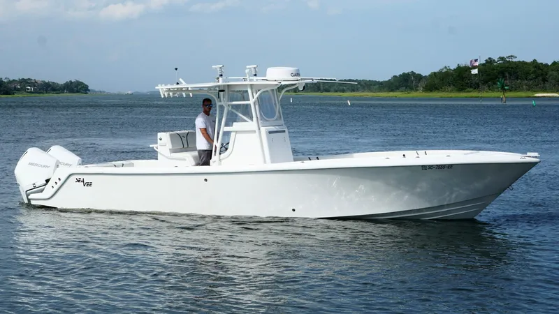Slide: The Image of 2004 SeaVee 310B boat on calm water, featuring a sleek white design. - 9