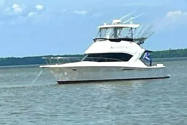 Slide: The Image of 2003 Riviera 350 yacht cruising on a calm lake under a clear blue sky. - 1