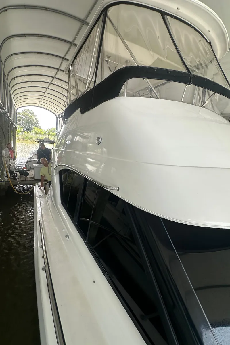 Slide: The Image of 2002 Riviera 350 yacht docked under a covered marina. - 10