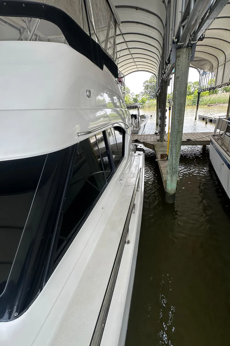 Slide: The Image of 2002 Riviera 350 yacht docked under covered marina. - 11