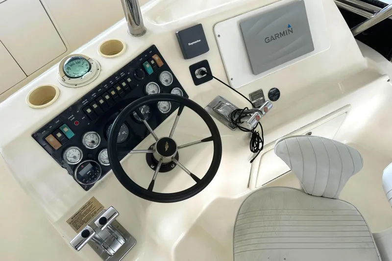 Slide: The Image of Cockpit of 2002 Riviera 350 boat with steering wheel and Garmin navigation system. - 15