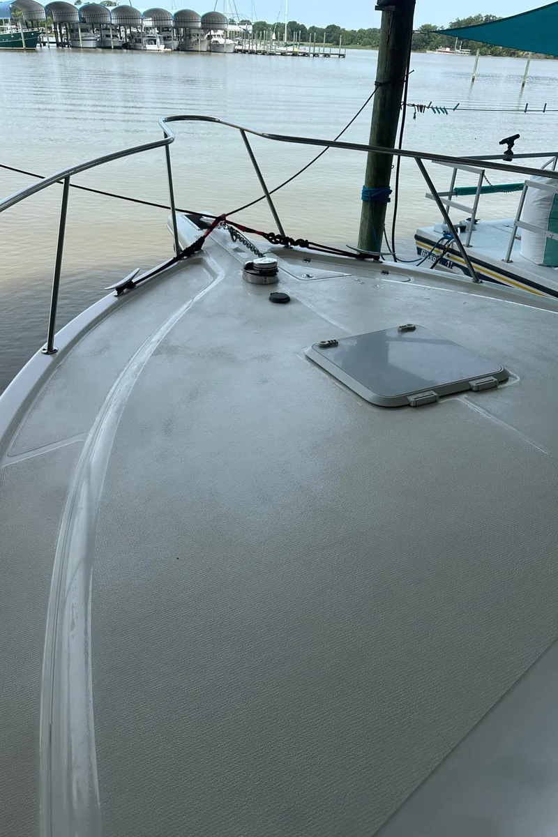 Slide: The Image of 2002 Riviera 350 boat deck with railing, docked by calm waters. - 22