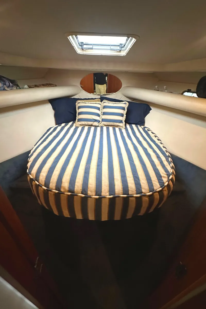 Slide: The Image of Cozy cabin interior of 2002 Riviera 350 with striped bedding and overhead hatch. - 24