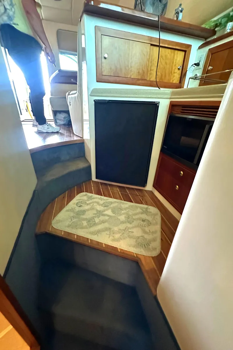 Slide: The Image of Interior of a 2002 Riviera 350 yacht with wooden cabinetry and carpeted steps. - 29