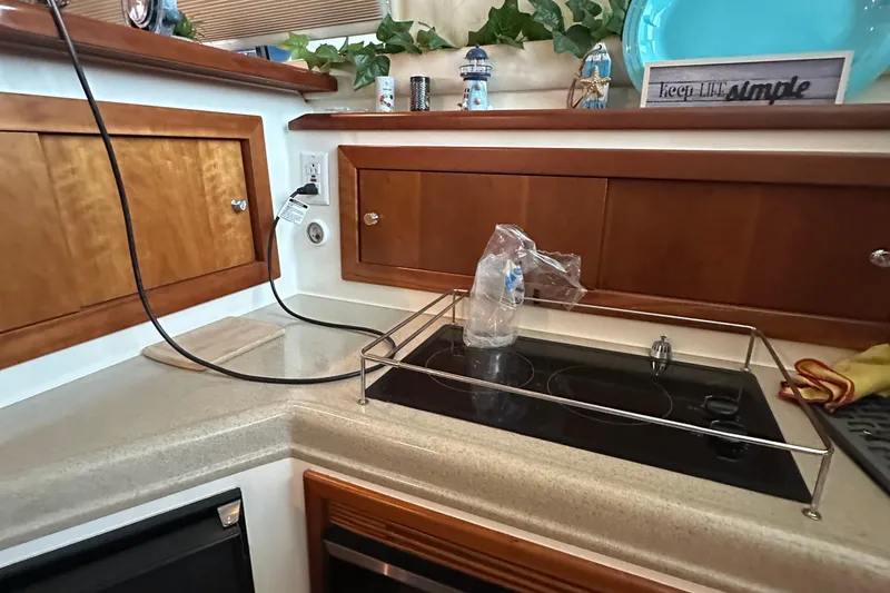 Slide: The Image of 2002 Riviera 350 yacht kitchen with stove, wooden cabinets, and decorative items. - 31