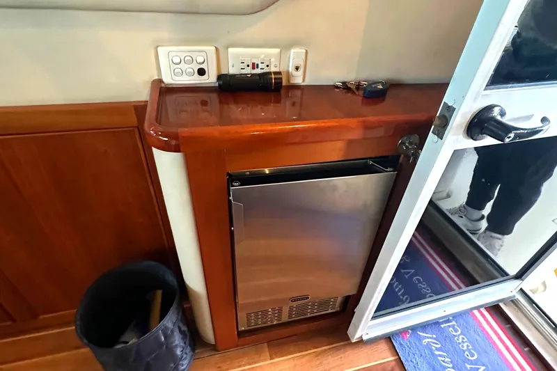 Slide: The Image of Interior of 2002 Riviera 350 yacht with mini fridge and wooden cabinetry. - 36
