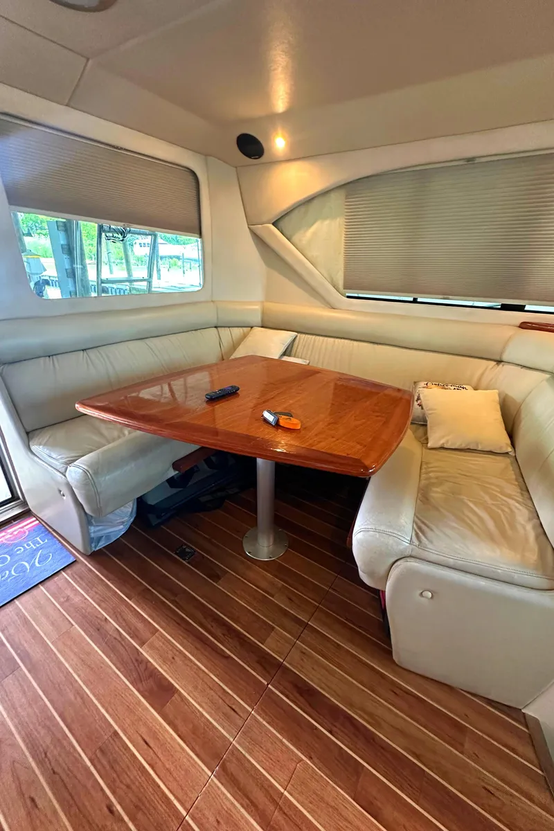 Slide: The Image of 2002 Riviera 350 yacht interior with wooden table, leather seating, and window blinds. - 37