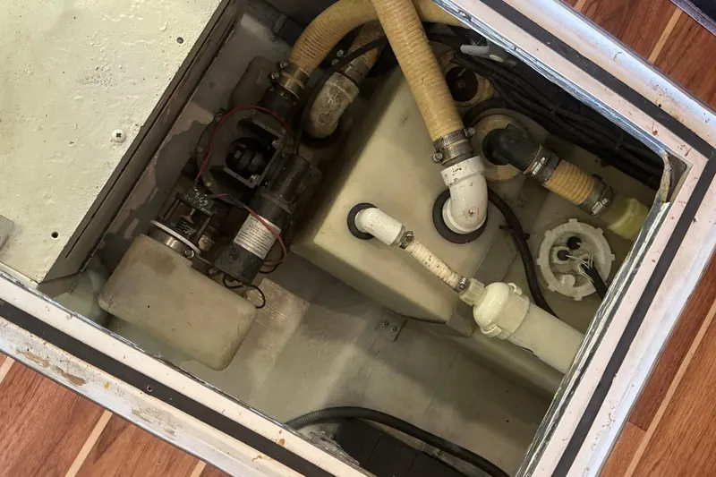 Slide: The Image of Engine compartment of a 2002 Riviera 350 boat, showing hoses and mechanical components. - 44