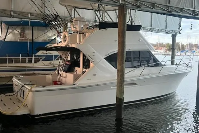 Slide: The Image of 2003 Riviera 350 yacht docked in a marina under a covered shelter. - 6