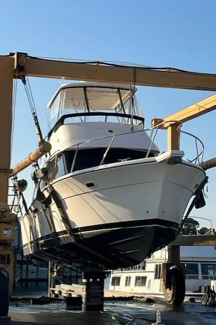 Slide: The Image of 2003 Riviera 350 yacht on a lift at a marina, clear sky background. - 7