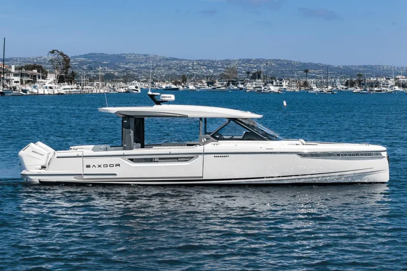 Slide: The Image of 2025 Saxdor 400 GTO luxury boat on calm water with marina background. - 2