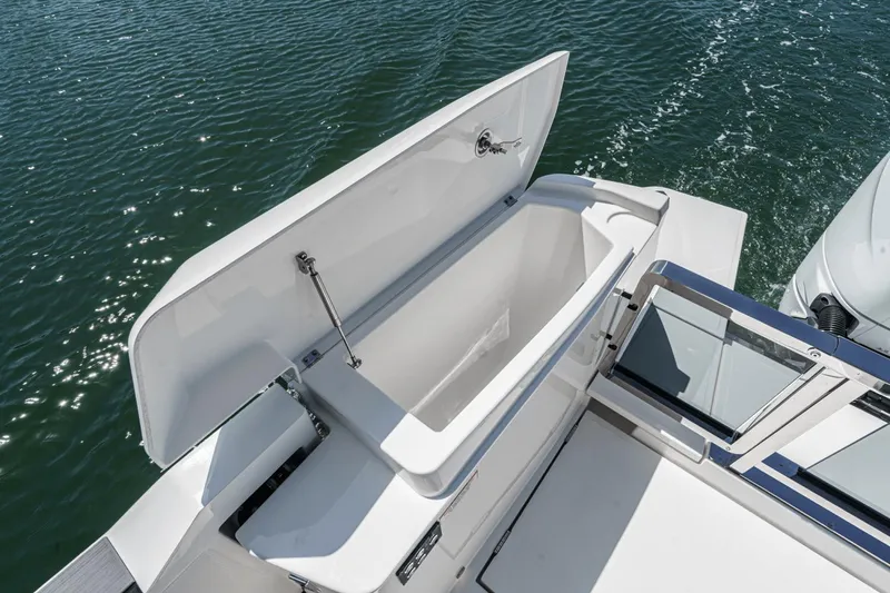 Slide: The Image of Open storage compartment on 2025 Saxdor 400 GTO boat, with water in the background. - 23