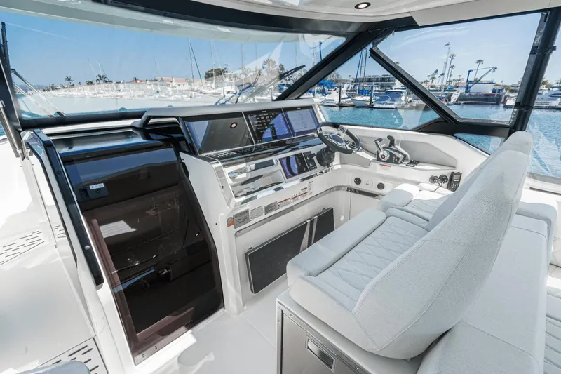 Slide: The Image of 2025 Saxdor 400 GTO cockpit with modern controls and luxurious seating, docked at a marina. - 43