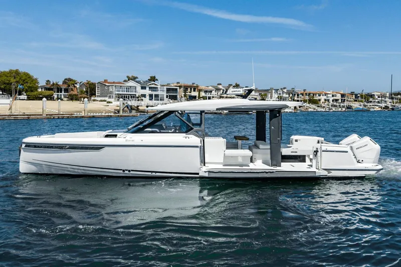 Slide: The Image of 2025 Saxdor 400 GTO luxury boat cruising on a sunny day near waterfront homes. - 6