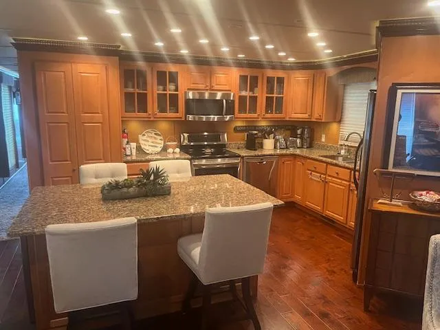 Slide: The Image of Luxurious kitchen in 2009 Horizon 18 x 85 houseboat with granite countertops and wooden cabinetry. - 14