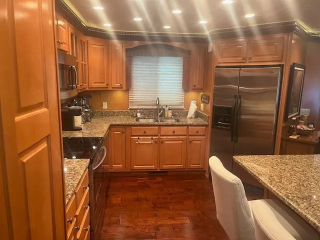 Slide: The Image of Luxurious kitchen in 2009 Horizon 18 x 85 houseboat with granite countertops and wooden cabinetry. - 18