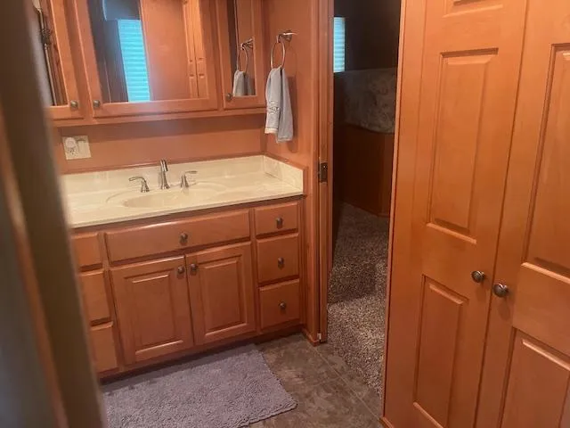 Slide: The Image of Interior of 2009 Horizon 18 x 85 Houseboat bathroom with wooden cabinets and sink. - 27