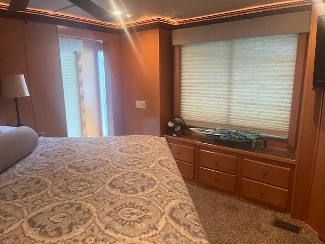 Slide: The Image of Cozy bedroom interior of 2009 Horizon 18 x 85 Houseboat with patterned bedding and wooden cabinetry. - 34