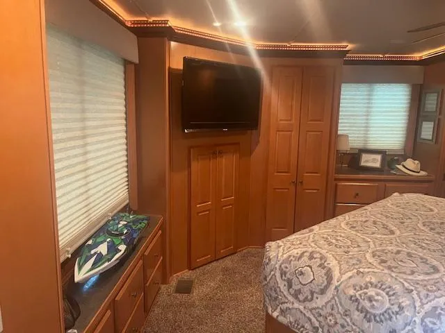 Slide: The Image of Interior of 2009 Horizon 18 x 85 Houseboat bedroom with TV and patterned bedding. - 35