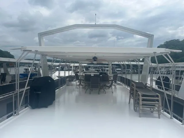 Slide: The Image of 2009 Horizon 18 x 85 Houseboat with spacious deck and outdoor seating under cloudy skies. - 43