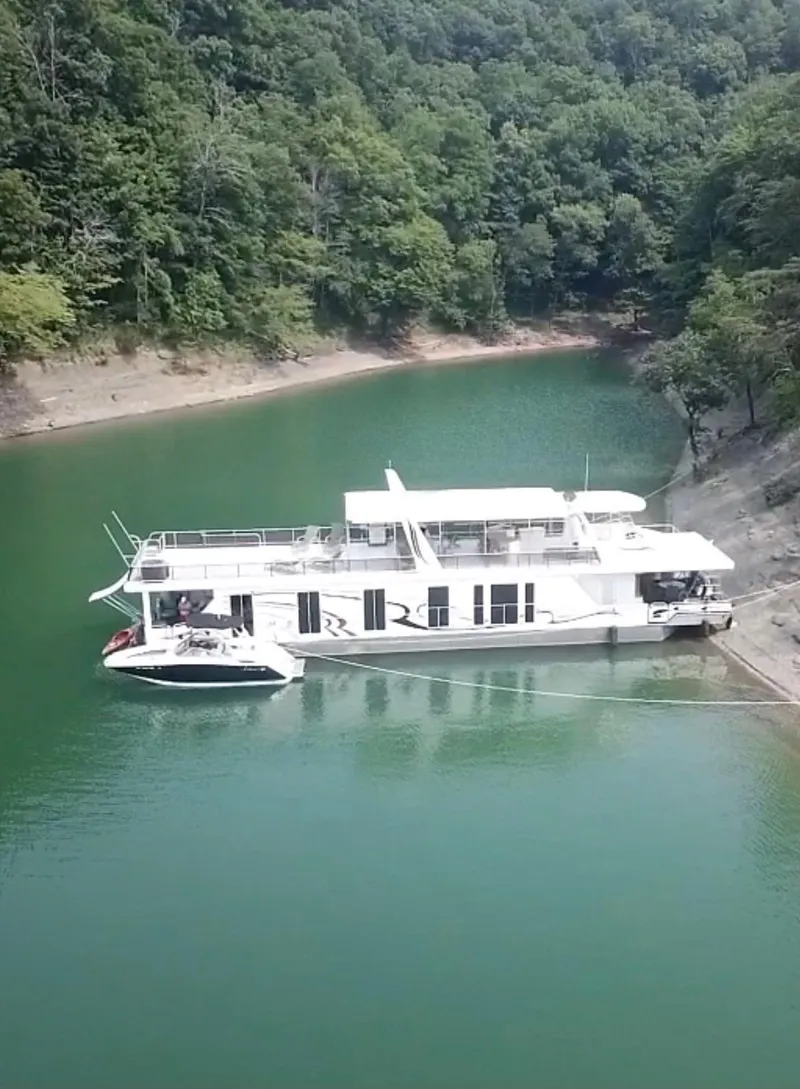 Slide: The Image of 2009 Horizon 18 x 85 Houseboat docked in a serene, forested lake setting. - 5