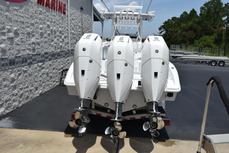 Slide: The Image of 2024 Yellowfin 36 Offshore boat with triple outboard engines, parked at a marina. - 3