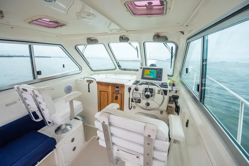 Slide: The Image of 2005 Back Cove Downeast Hardtop boat interior with steering wheel and navigation system. - 18