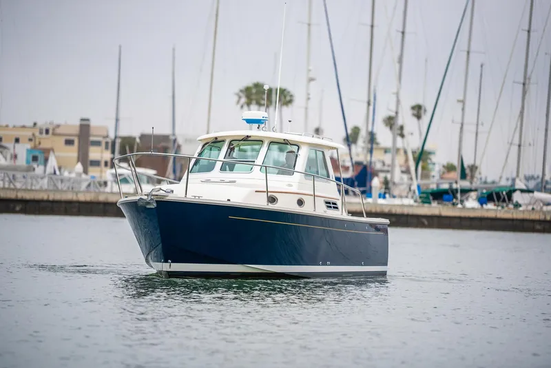Slide: The Image of 2005 Back Cove Downeast Hardtop boat on calm water near marina. - 2