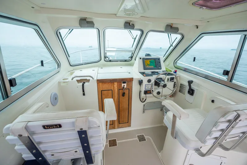 Slide: The Image of 2005 Back Cove Downeast Hardtop boat interior with steering wheel and navigation system. - 21