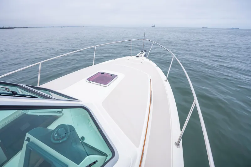Slide: The Image of 2005 Back Cove Downeast Hardtop boat on calm sea, showcasing deck and railing. - 27