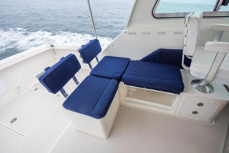 Slide: The Image of 2005 Back Cove Downeast Hardtop boat interior with blue cushioned seating. - 32