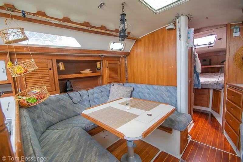 Slide: The Image of Cozy interior of 1992 Catalina 36 sailboat with dining area and wooden accents. - 12