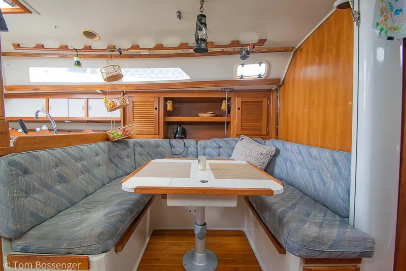 Slide: The Image of Cozy dining area in a 1992 Catalina 36 sailboat with cushioned seating and wooden accents. - 14