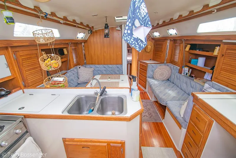 Slide: The Image of Interior of a 1992 Catalina 36 sailboat with cozy seating and a compact kitchen area. - 6