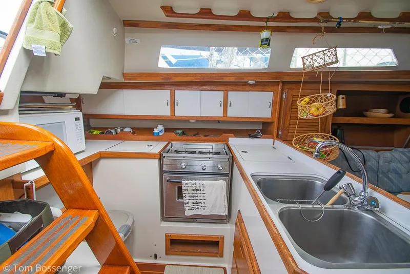 Slide: The Image of Interior of a 1992 Catalina 36 sailboat kitchen with wooden cabinetry and dual sinks. - 9