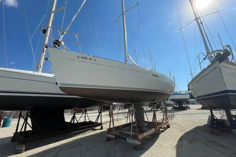The Image of 1996 Beneteau First 36s7 sailboat on dry dock under clear blue sky. - 0
