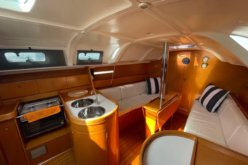 Slide: The Image of Interior of 1996 Beneteau First 36s7 yacht with cozy seating and modern kitchen amenities. - 12