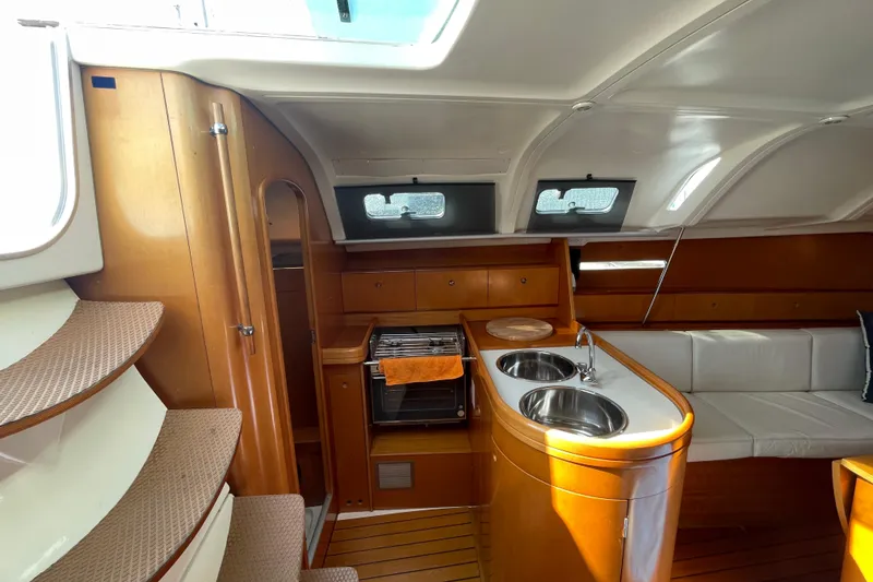 Slide: The Image of Interior of 1996 Beneteau First 36s7 yacht with kitchen and seating area. - 13